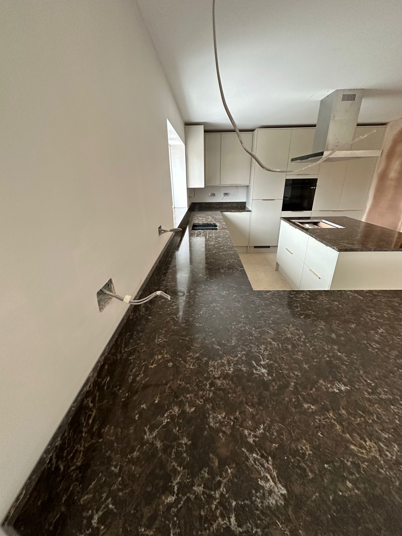 Dark brown granite worktop running the length of a kitchen